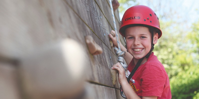 Child climbing on climbing wall at Aztec Adventure Upton Warren